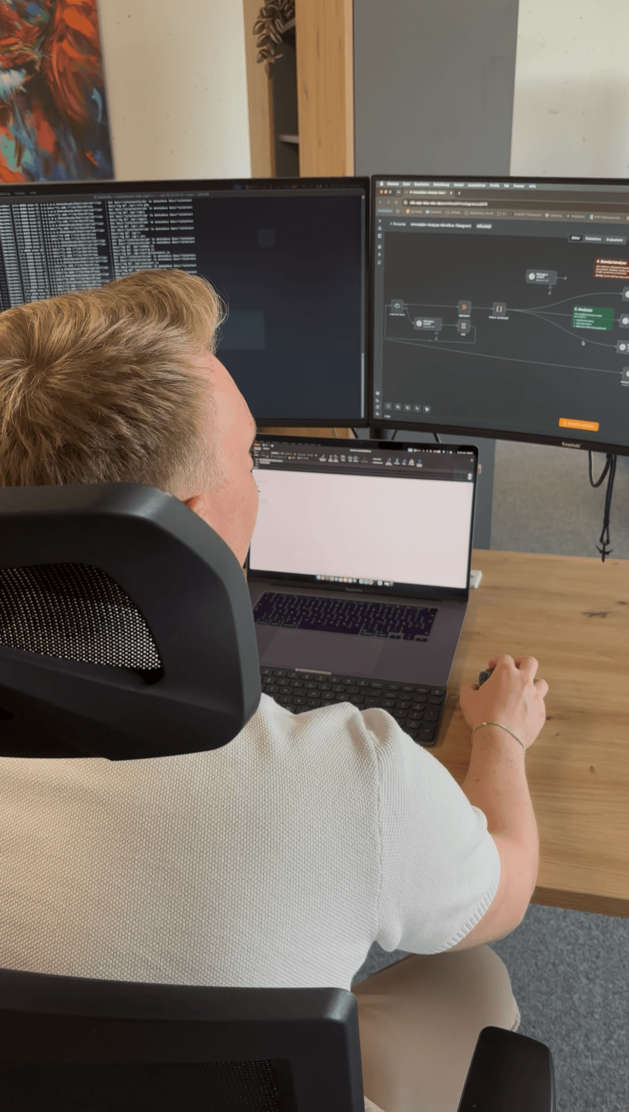 Leon Kulik an seinem Arbeitsplatz mit n8n-Workflows auf den Bildschirmen